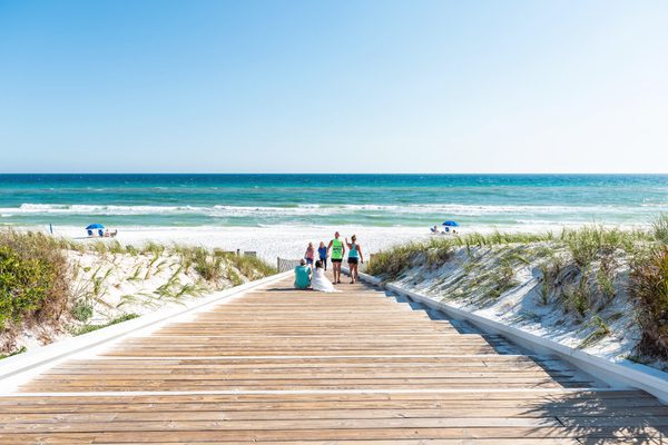 A family walks down a path to the beach at Seaside Beach Resort in Florida